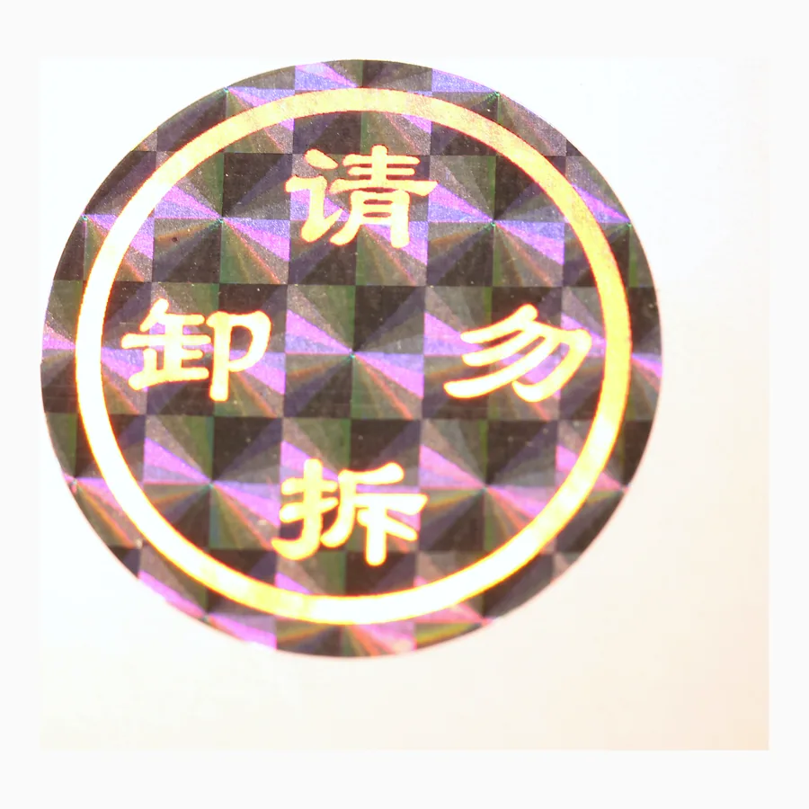 Circular tamper-evident holographic seal with a chequered diffraction field and warning text